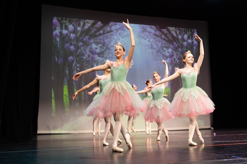Young ballerinas performing on stage.