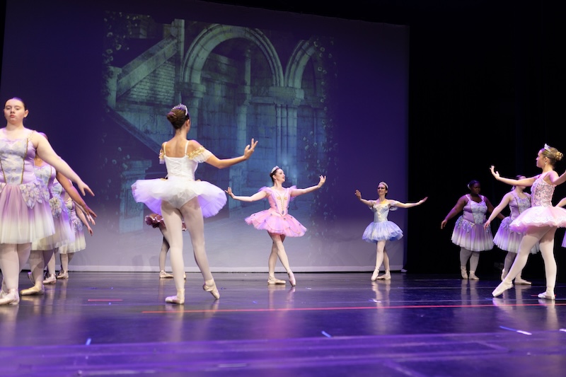 Young ballerinas performing on stage.