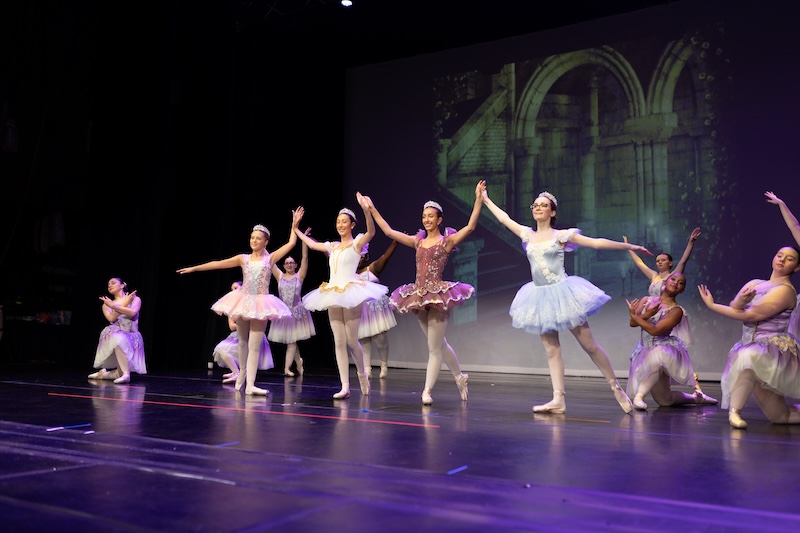Young ballerinas performing on stage.