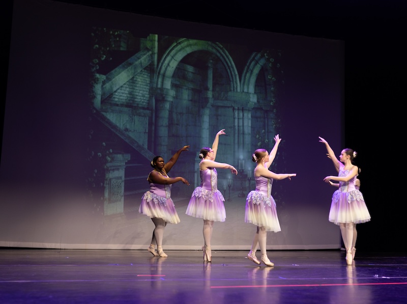 Young ballerinas performing on stage.