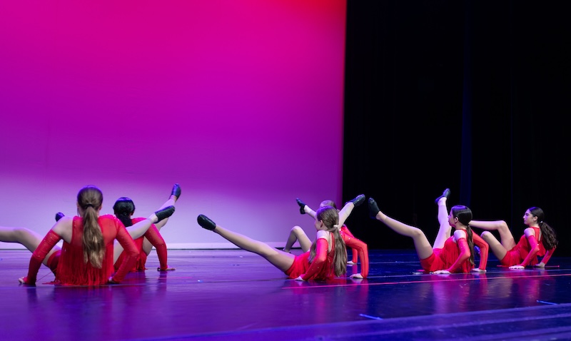 Young jazz dancers performing on stage.