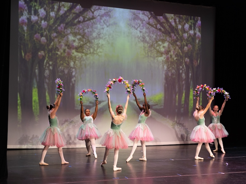 Young ballerinas performing on stage.