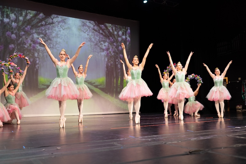 Young ballerinas performing on stage.